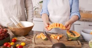 Summer, fruit and woman with papaya in kitchen ready to make healthy snack, fruit salad and lunch at home. Nutrition, food and people cutting tropical fruit for vegetarian, vegan and healthy diet