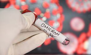 In this photo illustration, a health worker wearing gloves holding a test sample tubes labeled 'COVID-19 Omicron variant' in front of a display. More than 150 confirmed cases of the Omicron variant have been detected in India.