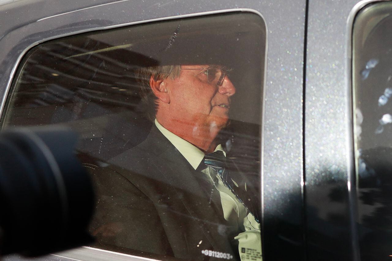 El expresidente brasileño Jair Bolsonaro gesticula dentro de un automóvil después de testificar en la sede de la Policía Federal en Brasilia el 5 de abril de 2023. (Foto de Sergio Lima / AFP)
