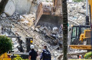 Maquinaria pesada retira escombros del edificio en condominio Champlain Towers South el jueves 8 de julio de 2021, en Surfside, Florida. (Pedro Portal/Miami Herald vía AP)