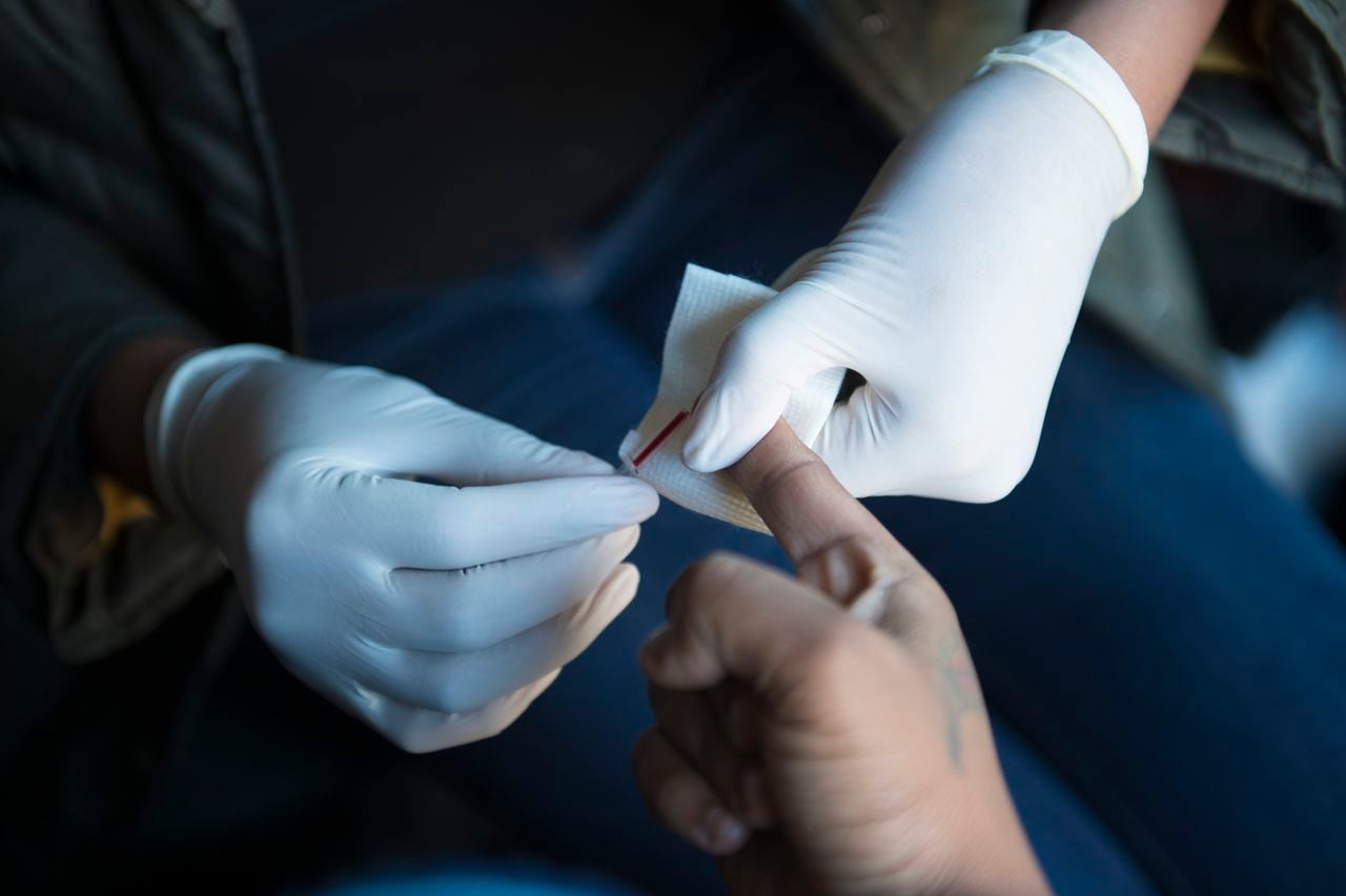 A Symone Ferrell, de 36 años, le extraen sangre para una prueba de VIH administrada por Cali Edmonds con el Colectivo de Mujeres, cerca del metro de Benning Road en Washington, D.C