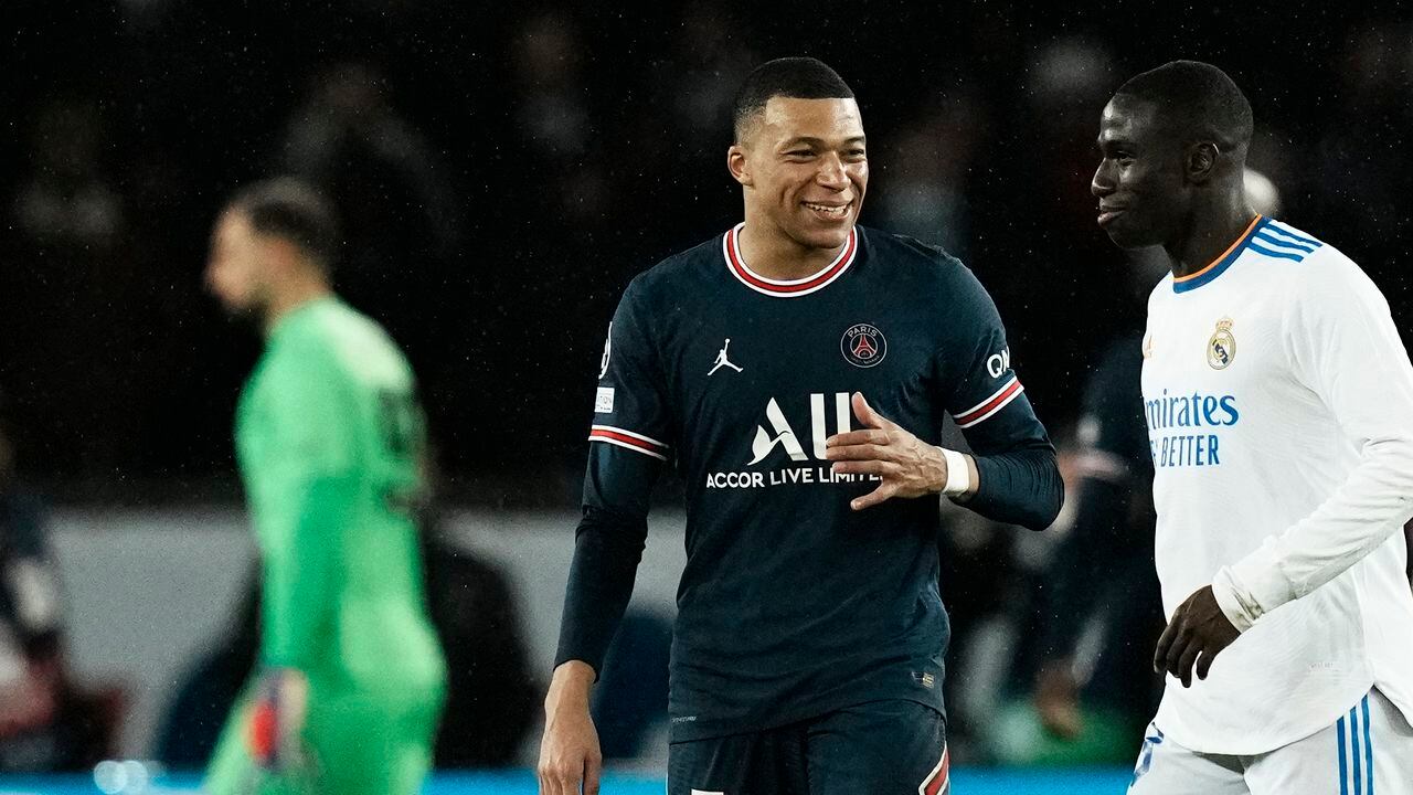 PSG's Kylian Mbappe, center, speaks with Real Madrid's Ferland Mendy during the Champions League, round of 16, first leg soccer match between Paris Saint Germain and Real Madrid at the Parc des Princes stadium, in Paris, France, Tuesday, Feb. 15, 2022. (AP Photo/Thibault Camus)