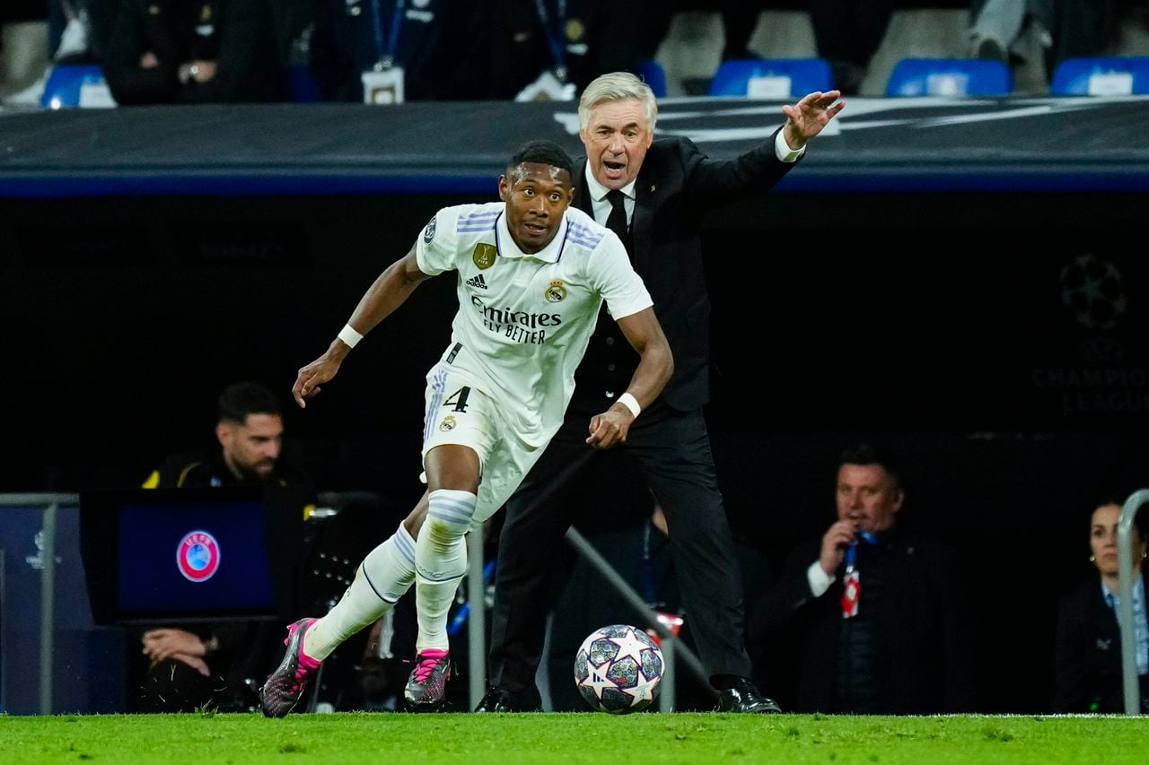Real Madrid's David Alaba runs with the ball near Real Madrid's head coach Carlo Ancelotti, background, during the Champions League quarter final first leg soccer match between Real Madrid and Chelsea at Santiago Bernabeu stadium in Madrid, Wednesday, April 12, 2023. Real Madrid won 2-0. (AP Photo/Jose Breton)