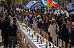 La gente se reúne alrededor de una mesa del Seder vacía con 133 sillas que representan a los rehenes tomados por Hamas el 7 de octubre, durante una protesta frente a Downing Street el 17 de abril de 2024 en Londres, Inglaterra.