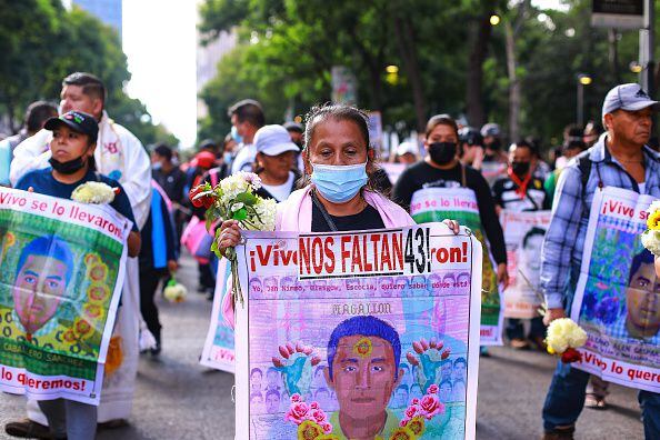 Manifestante sostiene una pancarta durante una manifestación para conmemorar el octavo aniversario de la desaparición de los estudiantes de Ayotzinapa el 26 de septiembre de 2022 en la Ciudad de México, México. El 26 de septiembre de 2014, 43 estudiantes de la Escuela Rural Isidro Burgos de Ayotzinapa desaparecieron en la ciudad de Iguala tras enfrentamientos con fuerzas policiales. Los estudiantes fueron acusados ​​de intentar el secuestro de autobuses para ser utilizados en protestas. (Foto de Manuel Velásquez/Getty Images)