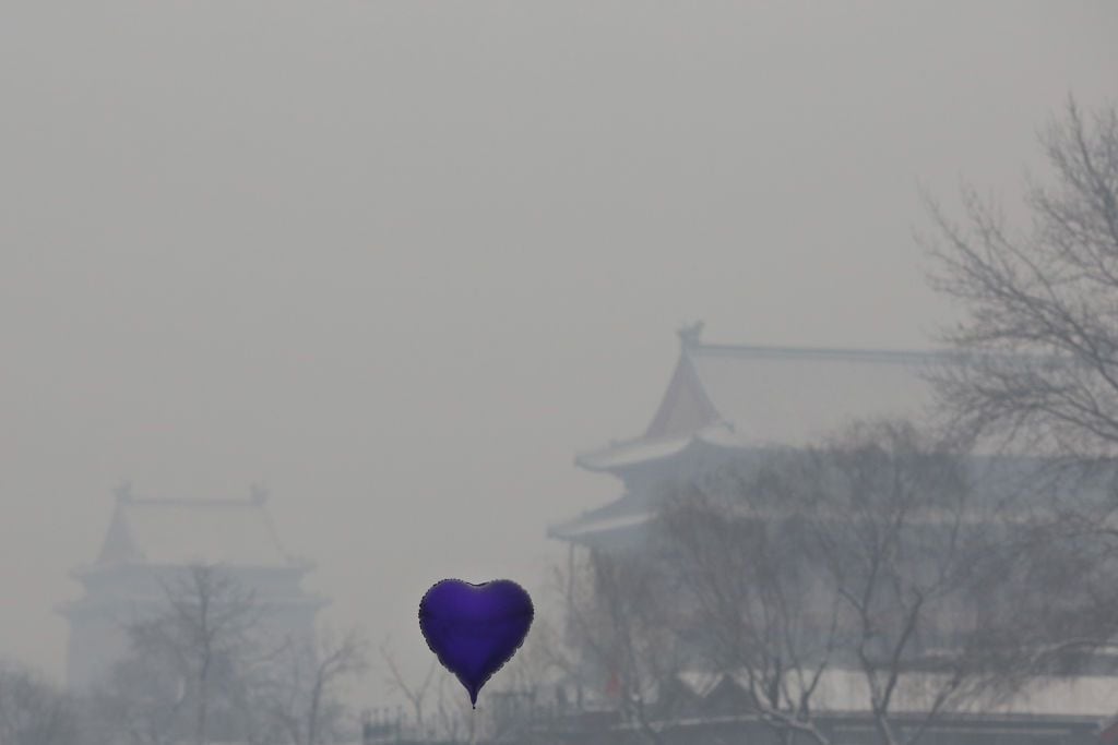 Se ve un globo en forma de corazón frente a la Torre del Tambor en el lago Houhai durante la contaminación severa el 3 de febrero de 2013 en Beijing, China. El lago Houhai es un lugar popular para los deportes de invierno y el entretenimiento en Beijing. (Foto de Feng Li/Getty Images)