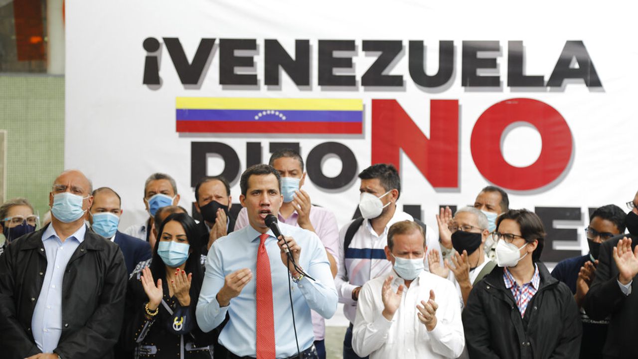 Flanked by party members, Venezuelan opposition leader Juan Guaido speaks during a press conference, a day after parliamentary elections, in Caracas, Venezuela, Monday, Dec. 7, 2020. Guaido rejected the results of Sunday's elections in which the government of President Nicolas Maduro declared victory in an election where the European Union said did not meet democratic standards and could not be considered credible. (AP Photo/Ariana Cubillos)