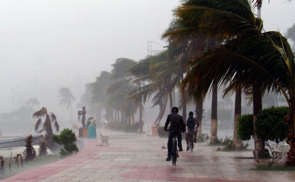 Dos hombres montan en bicicleta en paseo marítimo de La Paz de México, 6 de septiembre.