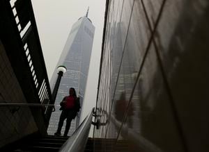 A commuter steps into the subway as smoke from wildfires in Canada partially obscure One World Trade Center in lower Manhattan, Tuesday, June 6, 2023, in New York. (AP Photo/Daniel P. Derella)