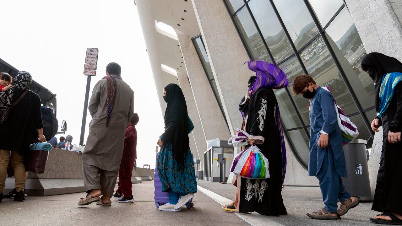 Las personas evacuadas de Kabul, Afganistán, esperan para abordar un autobús después de llegar al Aeropuerto Internacional Washington Dulles, en Chantilly, Virginia, el lunes 30 de agosto de 2021 (AP Photo / Jose Luis Magana).