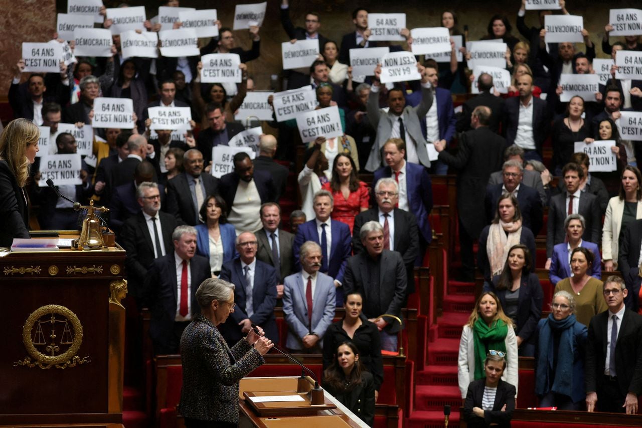 Los miembros del parlamento de izquierda sostienen pancartas y cantan la Marsellesa, el himno nacional francés, mientras la primera ministra francesa, Elisabeth Borne, llega para pronunciar un discurso sobre el proyecto de ley de reforma de las pensiones en la Asamblea Nacional en París, Francia