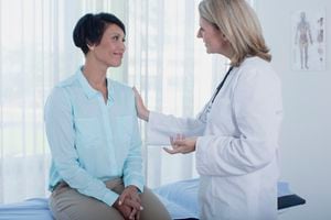 Smiling female doctor talking to patient in office