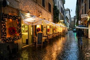 Un hombre pasa frente a un restaurante con adornos navideños, en Roma. El ministro de salud de Italia dijo a los legisladores el miércoles que Italia ha optado por comprar hasta 202,6 millones de dosis de vacunas anti-COVID-19 en "un esfuerzo sin precedentes que requerirá un gran compromiso colectivo". Foto: AP / Andrew Medichini.