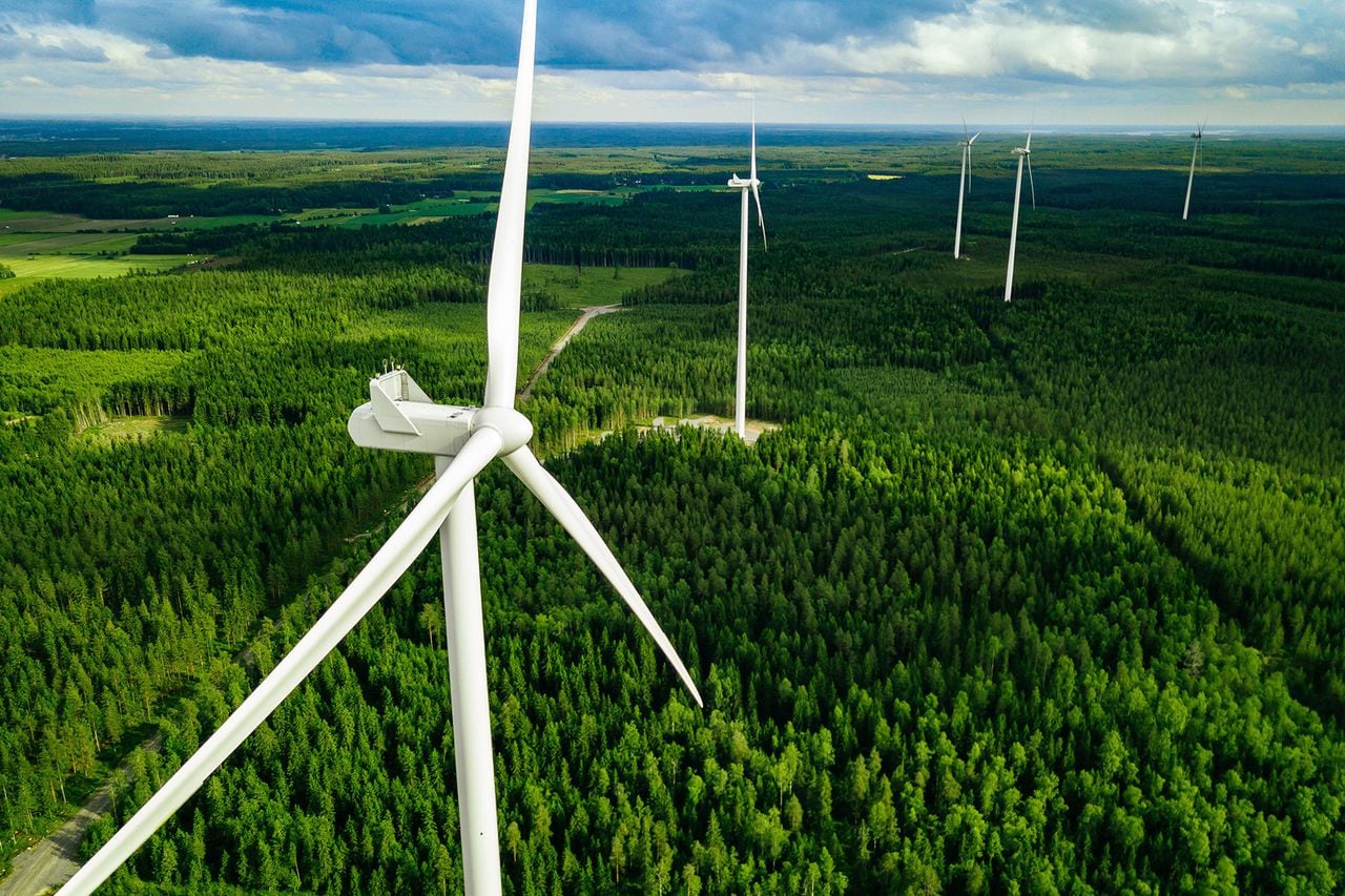Vista aérea de molinos de viento en bosque verde de verano en Finlandia. Aerogeneradores para energía eléctrica con Energías Limpias y Renovables