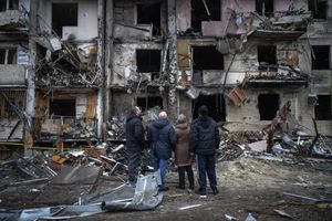 People look at the damage following a rocket attack the city of Kyiv, Ukraine, Friday, Feb. 25, 2022. (AP Photo/Emilio Morenatti)