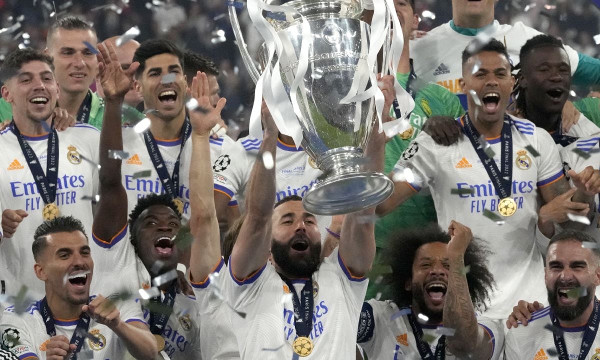 Real Madrid's Karim Benzema lifts the trophy as players celebrate winning the Champions League final soccer match between Liverpool and Real Madrid at the Stade de France in Saint Denis near Paris, Saturday, May 28, 2022. (AP/Frank Augstein)