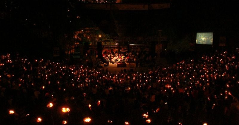 Foto de la clausura del Festival de Poesía de Medellín. Mucha gente con velas oyendo poesía