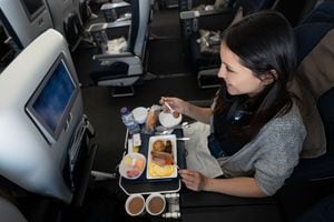 Una mujer viaja en avión y come a bordo - conceptos de viaje
