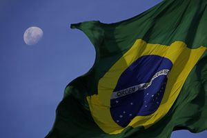 La bandera brasileña ondea con la luna detrás durante una protesta. Foto: AP / Eraldo Peres.