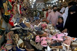 Una mujer busca zapatos para sus hijos mientras compra para el próximo feriado de Eid al-Fitr que marca el final del mes sagrado de ayuno musulmán del Ramadán, en un mercado en Peshawar, Pakistán, el jueves 6 de mayo de 2021. Foto: AP / Muhammad Sajjad.