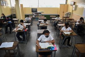 Los alumnos se sientan en el aula de una escuela en Caracas el 25 de octubre de 2021, cuando las instituciones educativas en Venezuela reabren después de más de un año y medio de aprendizaje remoto debido a la pandemia del nuevo coronavirus COVID-19. (Foto de Federico PARRA / AFP)