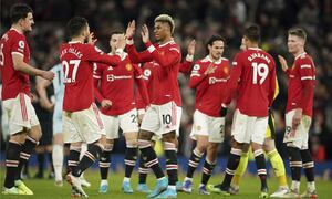 Manchester United's Marcus Rashford, center, celebrates with teammates after scoring his side's first goal during the English Premier League soccer match between Manchester United and West Ham at Old Trafford stadium in Manchester, England, Saturday, Jan. 22, 2022. (AP Photo/Dave Thompson)
