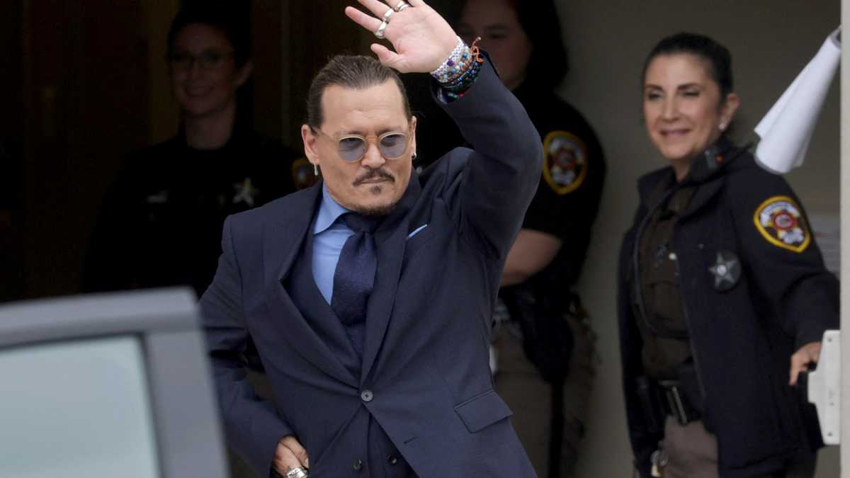 El actor estadounidense Johnny Depp se despide mientras sale de la corte de Fairfax.