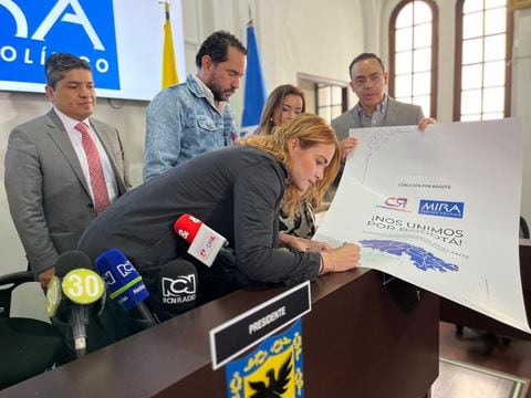 La representante Carolina Arbeláez y el concejal Rolando González firman el convenio por parte de Cambio Radical. Junto a ellos el senador de MIRA Carlos Guevara
