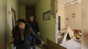 Dos mujeres recorren el interior de una escuela dañada, junto a otros edificios residenciales, en un bombardeo, en Kiev, Ucrania, el 18 de marzo de 2022. (Foto:AP/Rodrigo Abd)