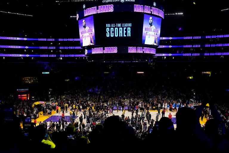 Fans cheer and media rush the floor for Los Angeles Lakers forward LeBron James after he passed Kareem Abdul-Jabbar to become the NBA's all-time leading scorer during the second half of an NBA basketball game against the Oklahoma City Thunder Tuesday, Feb. 7, 2023, in Los Angeles.(AP Photo/Marcio Jose Sanchez)