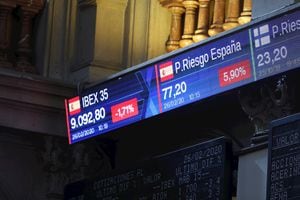 Un monitor en la Bolsa de Madrid muestra la evolución del indicador Ibex 35 y de la prima de riesgo español este miércoles.