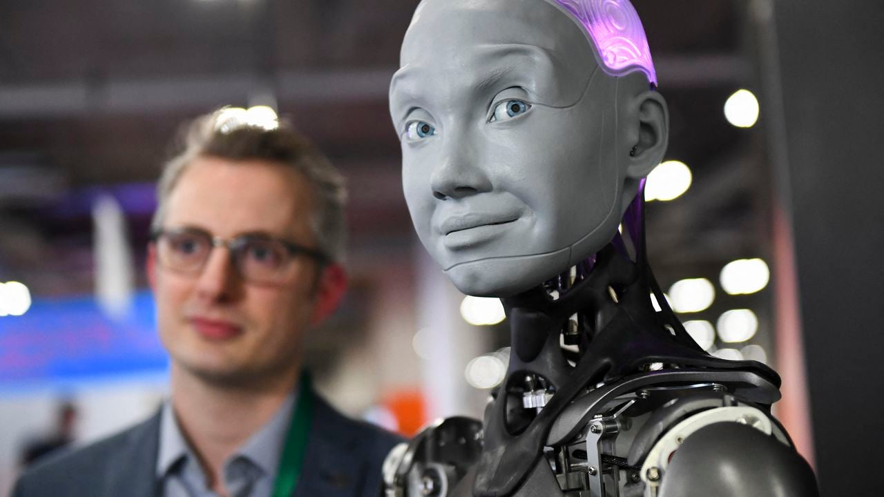 Morgan Roe, director de operaciones de Engineered Arts, habla sobre el robot humanoide Engineered Arts Ameca con inteligencia artificial como se demuestra durante el Consumer Electronics Show (CES) el 5 de enero de 2022 en Las Vegas, Nevada. (Foto de Patrick T.FALLON / AFP)