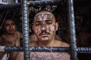 Miembros de la pandilla M18 miran a través de las rejas de la 'jaula de pandillas' designada M18 en la estación de policía de Quezaltepeque, El Salvador.(Photo by Giles Clarke/Getty Images.)