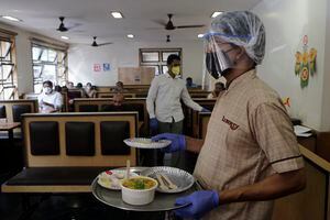 Un camarero sirve comida a los clientes en el hotel Liberty después de que los restaurantes en el estado reanudaran sus servicios el lunes, meses después de que cerraran debido a la pandemia de COVID-19 en Mumbai, India, el lunes 5 de octubre de 2020. Foto: AP / Rajanish Kakade