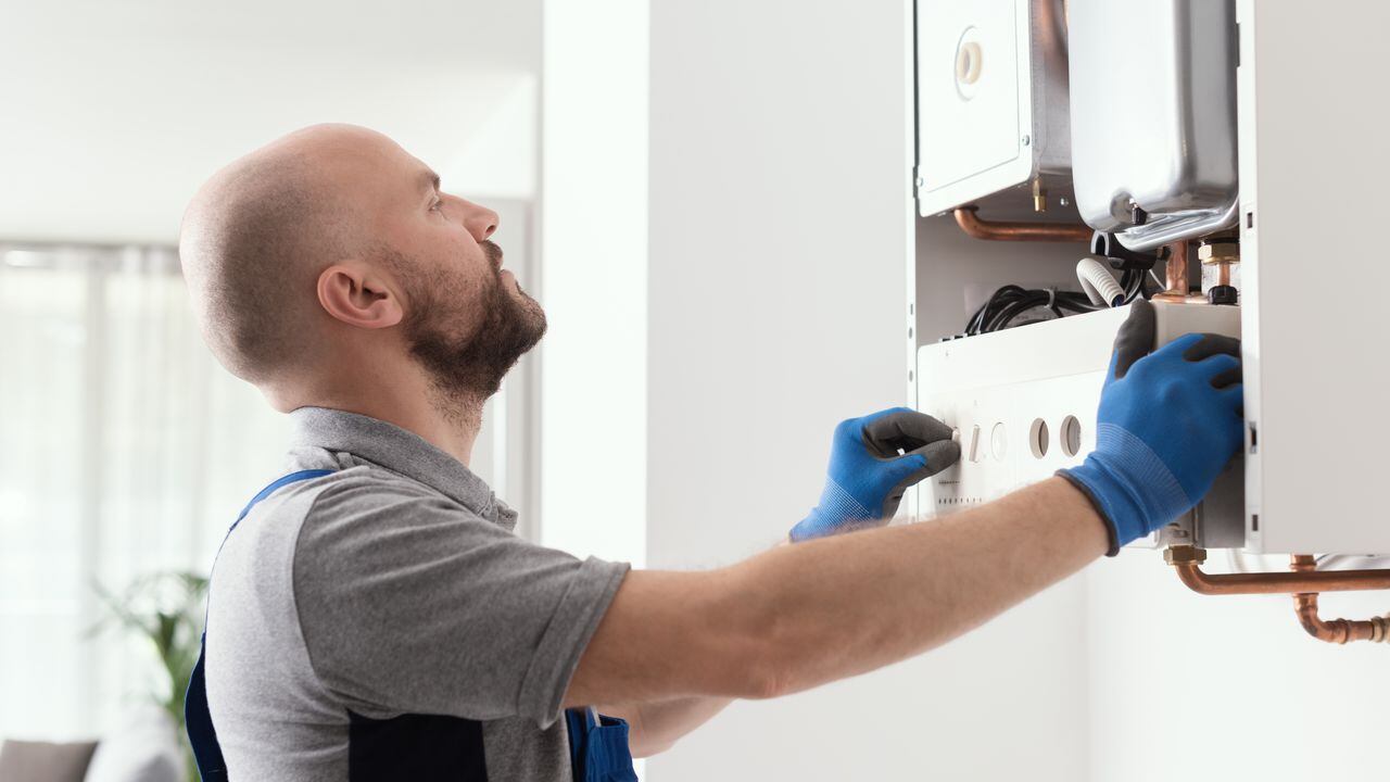 Professional qualified engineer testing a gas boiler after repair