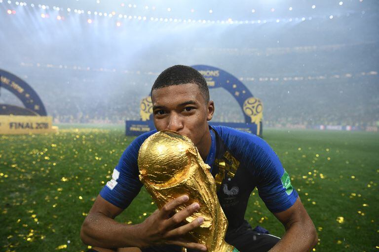(FILES) In this file photo taken on July 15, 2018 France's forward Kylian Mbappe kisses the World Cup trophy after the Russia 2018 World Cup final football match between France and Croatia at the Luzhniki Stadium in Moscow. - Regarding Europe's already supremacy over South America, the upcoming Qatar 2022 World Cup could either consolidate the trend or be a turning point. The outlook for South America for does not look much encouraging as the gap has widened in almost all areas: economic potential, more competitive tournaments and the exodus of youngsters from the region at an increasingly younger age. (Photo by FRANCK FIFE / AFP) / RESTRICTED TO EDITORIAL USE - NO MOBILE PUSH ALERTS/DOWNLOADS