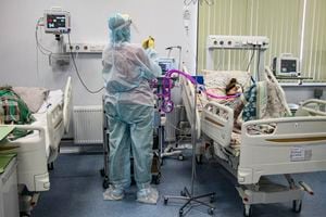 Un trabajador médico con ropa de protección contra los contagios de COVID-19 atiende a un paciente en la UCI del Hospital Número 23 en Nizhny Novgorod, Rusia, el miércoles 20 de octubre de 2021. (AP Foto/Roman Yarovitcyn)