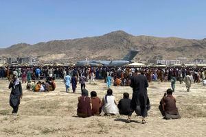 Fotografía de archivo del 16 de febrero de 2021, cientos de personas se reúnen cerca de EE. UU. Avión de transporte Air Force C-17 a lo largo del perímetro del aeropuerto internacional de Kabul, Afganistán. Cientos de ciudadanos occidentales y trabajadores afganos han sido trasladados a un lugar seguro desde que los talibanes reafirmaron el control del país. Sin embargo, todavía desprotegidos y escondidos, hay un número incalculable de afganos que intentaron construir una democracia incipiente. Incluyen afganos que trabajaron con fuerzas extranjeras y que ahora están varados y siendo perseguidos por los talibanes, junto con trabajadores humanitarios. (AP Photo/Shekib Rahmani, File)