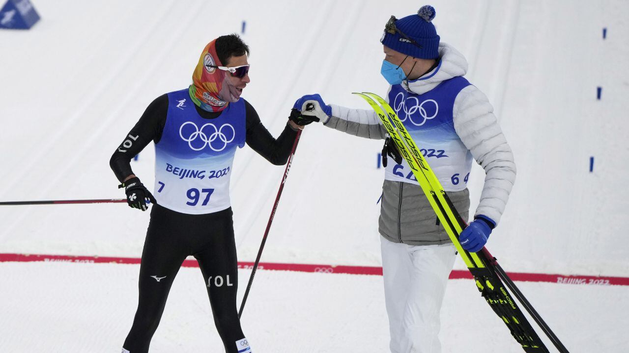 Gold medal finisher Iivo Niskanen, of Finland, right, congratulates last place finisher Carlos Andres Quintana, of Colombia, during the men's 15km classic cross-country skiing competition at the 2022 Winter Olympics, Friday, Feb. 11, 2022, in Zhangjiakou, China. (AP Photo/Aaron Favila)