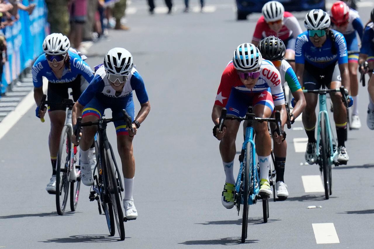 La cubana Arlenis Sierra (derecha) y la venezolana Lilibeth Chacón (izquierda) compiten en la carrera de ciclismo de ruta en San Salvador, el viernes 7 de julio de 2023, en los Juegos Centroamericanos y del Caribe (AP Foto/Arnulfo Franco)