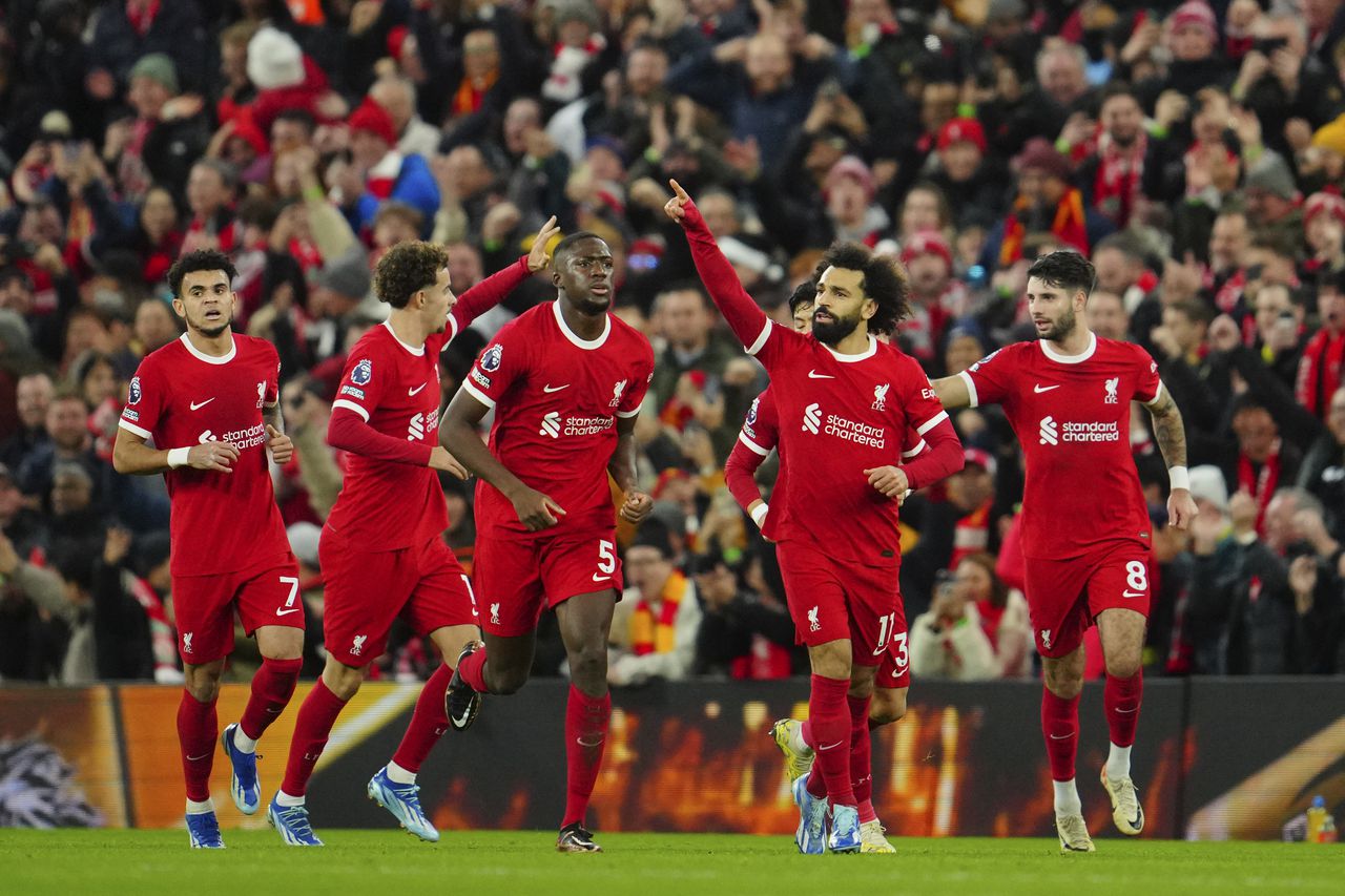 Liverpool's Mohamed Salah, second right, celebrates after scoring his side's opening goal during the English Premier League soccer match between Liverpool and Arsenal at Anfield stadium in Liverpool, England, Saturday, Dec. 23, 2023. (AP Photo/Jon Super)