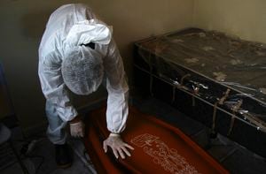 A public funeral service worker helps to remove the body of Jose Bernardino Ferreira, 77, who died from complications related to COVID-19 in his home, in Manaus, Amazonas state, Friday, Jan. 22, 2021. The number of people who die in their homes amid the new coronavirus pandemic is growing due to the lack of availability in hospitals and the shortage of oxygen. (AP Photo/Edmar Barros)