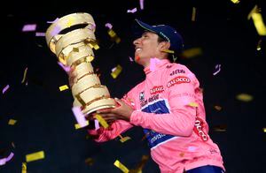 El colombiano Nairo Quintana sostiene el trofeo mientras celebra en el podio con el líder del maillot rosa de la clasificación general, tras ganar la 97ª carrera ciclista del Giro de Italia, al final de la 21ª y última etapa, de 172 kilómetros. de Gemona a Trieste, el 1 de junio de 2014 en Trieste. AFP PHOTO/LUK BENIES (Foto de LUK BENIES / AFP)