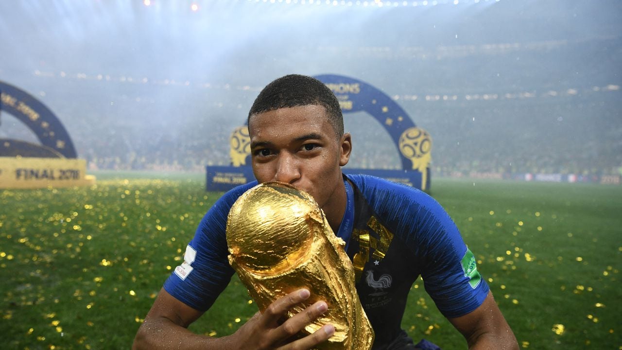 (FILES) In this file photo taken on July 15, 2018 France's forward Kylian Mbappe kisses the World Cup trophy after the Russia 2018 World Cup final football match between France and Croatia at the Luzhniki Stadium in Moscow. - Regarding Europe's already supremacy over South America, the upcoming Qatar 2022 World Cup could either consolidate the trend or be a turning point. The outlook for South America for does not look much encouraging as the gap has widened in almost all areas: economic potential, more competitive tournaments and the exodus of youngsters from the region at an increasingly younger age. (Photo by FRANCK FIFE / AFP) / RESTRICTED TO EDITORIAL USE - NO MOBILE PUSH ALERTS/DOWNLOADS