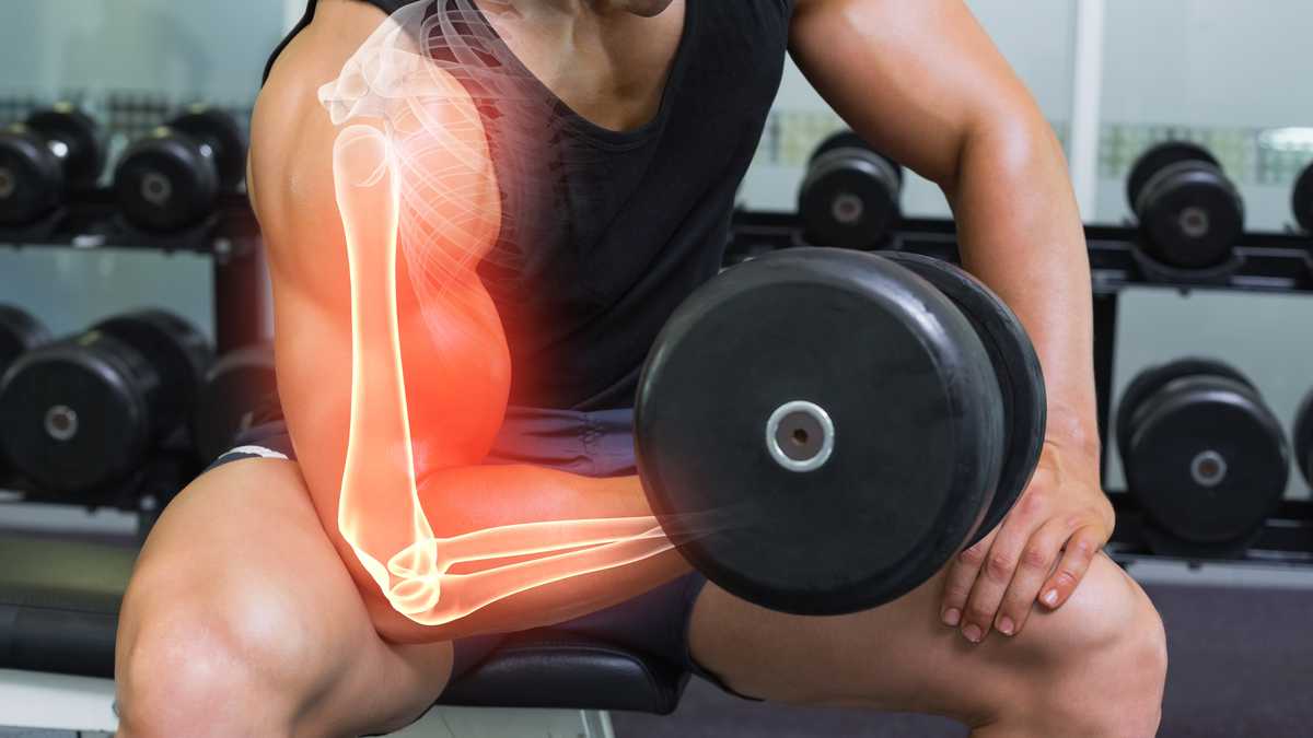 Highlighted arm of strong man lifting weights