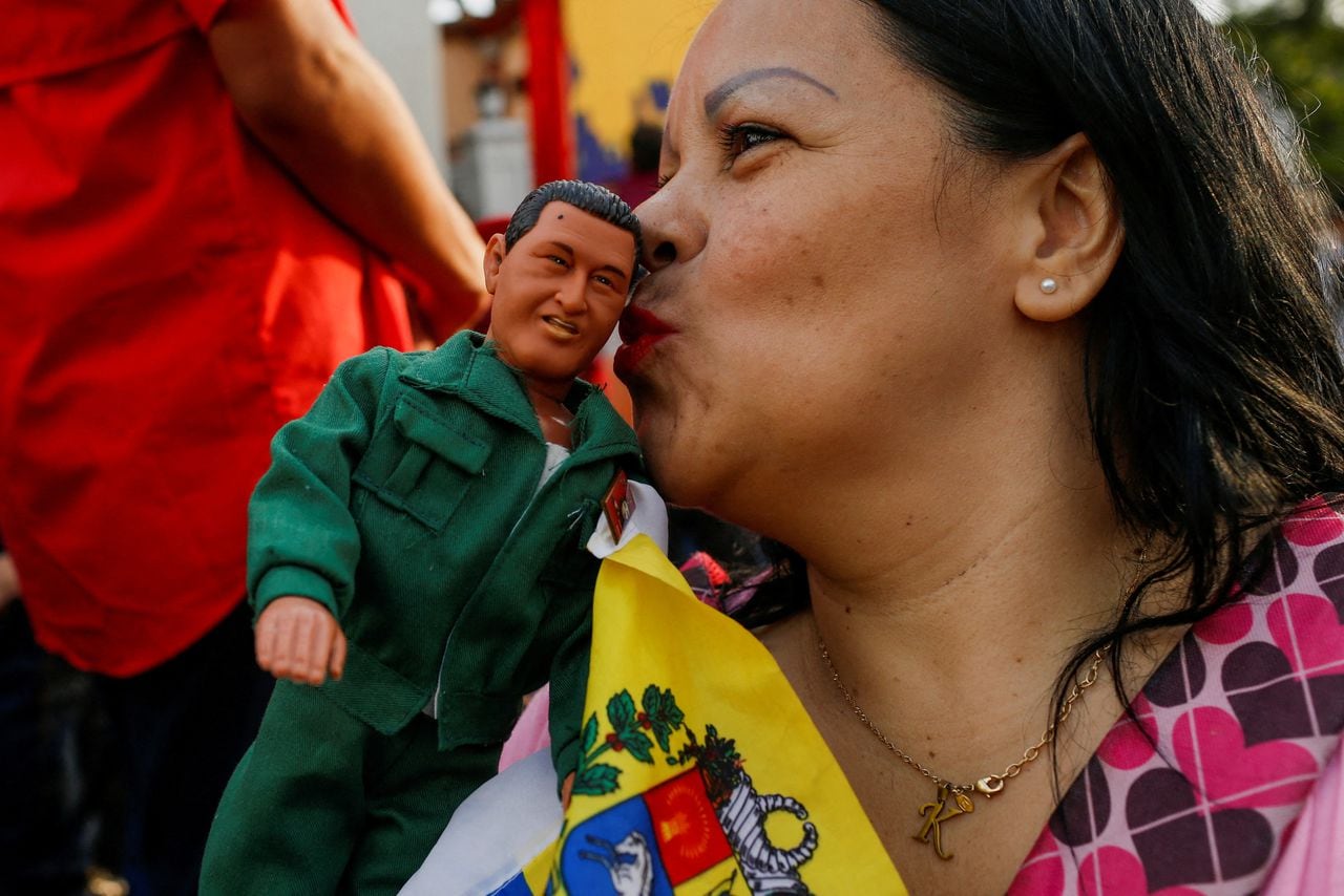 Un partidario del gobierno besa un juguete que representa al difunto presidente venezolano Hugo Chávez durante la celebración del 21 aniversario del regreso al poder del difunto presidente Hugo Chávez después de un fallido intento de golpe de Estado en 2002