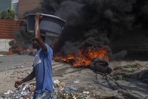 Llantas en llamas bloquean una carretera, colocada por manifestantes en Puerto Príncipe, Haití. Foto AP / Joseph Odelyn.