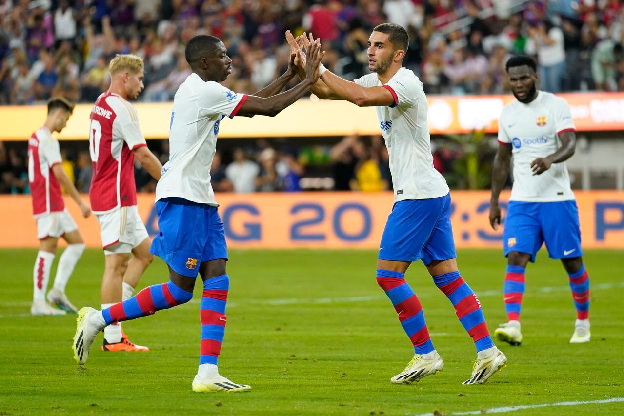 FC Barcelona forward Ferran Torres, center, celebrates with FC Barcelona forward Ousmane Dembele after scoring during the second half of a Champions Cup soccer match against Arsenal FC, Wednesday, July 26, 2023, in Inglewood, Calif. (AP Photo/Ashley Landis)