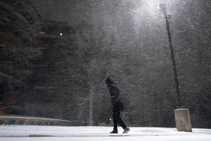 Una mujer camina bajo una nevada en San Anotnio, el domingo 14 de febrero de 2021. El hielo y la nieve cubrieron buena parte de Estados Unidos el domingo, provocando cancelaciones de vuelos, complicando los desplazamientos y llegando a zonas tan al sur como la costa texana del Golfo de México. (AP Foto/Eric Gay)