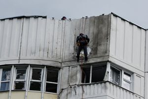 Trabajadores reparan daños en el techo de un bloque de apartamentos de varias plantas tras un ataque con drones en Moscú, Rusia, el 30 de mayo de 2023.